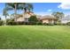 House exterior featuring a beautiful lawn and palm trees at 39539 Harbor Hills Blvd, Lady Lake, FL 32159