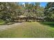House exterior showcasing a long driveway and lush landscaping at 5415 Banana Point Dr, Okahumpka, FL 34762