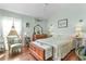 Serene bedroom with wood floors, antique furniture, and a comfortable sitting area at 747 Bradford Loop, The Villages, FL 32163