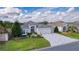 Single-story home with a gray roof, paved driveway, and landscaped lawn at 747 Bradford Loop, The Villages, FL 32163