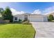 Single-story home with a three-car garage and landscaped yard at 747 Bradford Loop, The Villages, FL 32163
