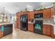 Spacious kitchen with dark wood cabinets, black appliances, and tile flooring at 747 Bradford Loop, The Villages, FL 32163