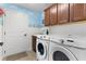 Convenient laundry room with washer, dryer, and cabinets at 747 Bradford Loop, The Villages, FL 32163