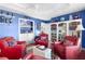 Charming sitting area with red armchairs, built-in bar and bookshelves at 747 Bradford Loop, The Villages, FL 32163