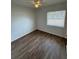 Empty bedroom with wood-look flooring, white walls, and a single window at 8 S Solandra Dr, Orlando, FL 32807