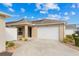 Exterior view of a home with a two-car garage, solar panels, and landscaped yard at 867 Parrish Pl, The Villages, FL 32163