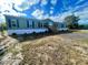 Mobile home exterior, showcasing green siding, white accents, and a landscaped yard at 9018 Atlas Dr, Saint Cloud, FL 34773