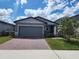 Charming single-Gathering home with a gray exterior, paved driveway, and landscaped yard at 964 Rivers Crossing St, Clermont, FL 34714