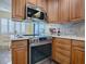 Stainless steel appliances and wood cabinets highlight this kitchen at 102 Cedar Way, Yalaha, FL 34797