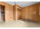Bedroom with wood paneled walls, carpeted floor, and double doors at 11451 Pala Verda Ave, Leesburg, FL 34788