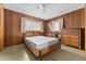 Main bedroom with wood paneled walls, ceiling fan and ensuite bathroom at 11451 Pala Verda Ave, Leesburg, FL 34788