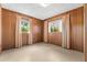 Empty bedroom with wood paneling and neutral carpeting at 11451 Pala Verda Ave, Leesburg, FL 34788