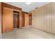 Bedroom with wood paneling, closet, and neutral carpet at 11451 Pala Verda Ave, Leesburg, FL 34788