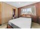 Main bedroom with ensuite bathroom, wood paneling and ceiling fan at 11451 Pala Verda Ave, Leesburg, FL 34788