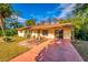 Yellow ranch home with a large yard and palm tree at 11451 Pala Verda Ave, Leesburg, FL 34788