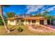 Yellow ranch home with a large yard and palm tree at 11451 Pala Verda Ave, Leesburg, FL 34788