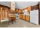 Retro kitchen features wood cabinets, white appliances, and a breakfast bar at 11451 Pala Verda Ave, Leesburg, FL 34788