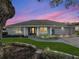 Inviting front view of home illuminated at twilight, easy-care landscape, mature trees at 11584 Se 175Th St, Summerfield, FL 34491