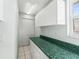 Laundry room with green countertop, white cabinets, and tile flooring at 11584 Se 175Th St, Summerfield, FL 34491