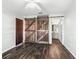 Main bedroom featuring barn doors, wood-look floors, and ensuite bathroom access at 11584 Se 175Th St, Summerfield, FL 34491