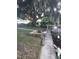 Backyard with a large oak tree, dock, and sitting area at 12141 Lake Pines Rd, Leesburg, FL 34788
