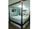 Bedroom featuring a four-poster bed, wood-look flooring, and soft green walls at 12141 Lake Pines Rd, Leesburg, FL 34788