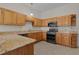 Well-equipped kitchen with granite countertops and wood cabinets at 1245 Avenida De Las Casas, The Villages, FL 32159