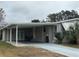 Mobile home with carport, covered walkway and landscaped yard at 1335 E Schwartz Blvd, Lady Lake, FL 32159