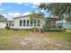 Home's backyard with a screened-in porch, lush lawn, and landscaping at 1715 Lilly Ln, Lady Lake, FL 32159
