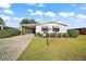 Charming single-story home with a paved driveway and landscaped yard at 1715 Lilly Ln, Lady Lake, FL 32159
