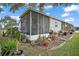 Exterior of home with screened porch and lush greenery at 1715 Lilly Ln, Lady Lake, FL 32159