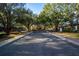 Landscaped entrance to community with mature trees and golf carts at 26670 Otter Creek Ln, Leesburg, FL 34748