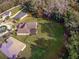 An aerial perspective of the backyard, complete with a screened porch, lush lawn, and play area at 3556 Creek Run Ln, Eustis, FL 32736