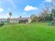 Spacious backyard with a screened-in patio, lush green lawn, and a playground set at 3556 Creek Run Ln, Eustis, FL 32736
