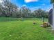 Private fenced backyard with lush lawn, playset, and seating area at 3556 Creek Run Ln, Eustis, FL 32736