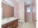 Pink bathroom with tiled shower, vanity sink, and toilet at 3556 Creek Run Ln, Eustis, FL 32736