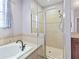 Bathroom featuring a tiled walk-in shower, soaking tub, and window with patterned curtains at 3556 Creek Run Ln, Eustis, FL 32736