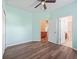Bedroom with wood-look floors, open doors and a ceiling fan at 3556 Creek Run Ln, Eustis, FL 32736