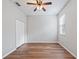 Empty bedroom with wood-look flooring, white closet doors, and ceiling fan at 3556 Creek Run Ln, Eustis, FL 32736