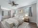 Inviting bedroom with plush bed, wood-look floors, ceiling fan, and ample natural light at 3556 Creek Run Ln, Eustis, FL 32736