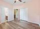 Pink bedroom with wood-look flooring, white closet, open door, and ceiling fan at 3556 Creek Run Ln, Eustis, FL 32736