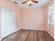 Pink bedroom with wood-look flooring, white closet, and ceiling fan at 3556 Creek Run Ln, Eustis, FL 32736