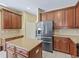 Kitchen boasts a large island, stainless steel refrigerator, and wood cabinets at 3556 Creek Run Ln, Eustis, FL 32736