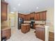 Spacious kitchen with island, wood cabinets, and black appliances at 3556 Creek Run Ln, Eustis, FL 32736