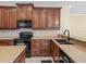 Kitchen features wood cabinetry, black appliances, and ample counter space at 3556 Creek Run Ln, Eustis, FL 32736