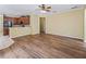 Living area with wood-look floors, ceiling fan, and adjacent kitchen with breakfast bar at 3556 Creek Run Ln, Eustis, FL 32736
