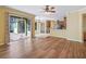 Living room with wood-look floors, ceiling fan, and sliding glass doors to the patio at 3556 Creek Run Ln, Eustis, FL 32736