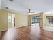 Open living room with wood-look flooring, ceiling fan, and sliding glass doors to screened patio at 3556 Creek Run Ln, Eustis, FL 32736