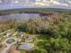 Scenic aerial view showcasing the neighborhood's proximity to a tranquil lake, surrounded by trees at 3556 Creek Run Ln, Eustis, FL 32736
