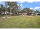 Charming yellow house with a large front yard, mature trees, and a water fountain at 606 N Shore Dr, Leesburg, FL 34748